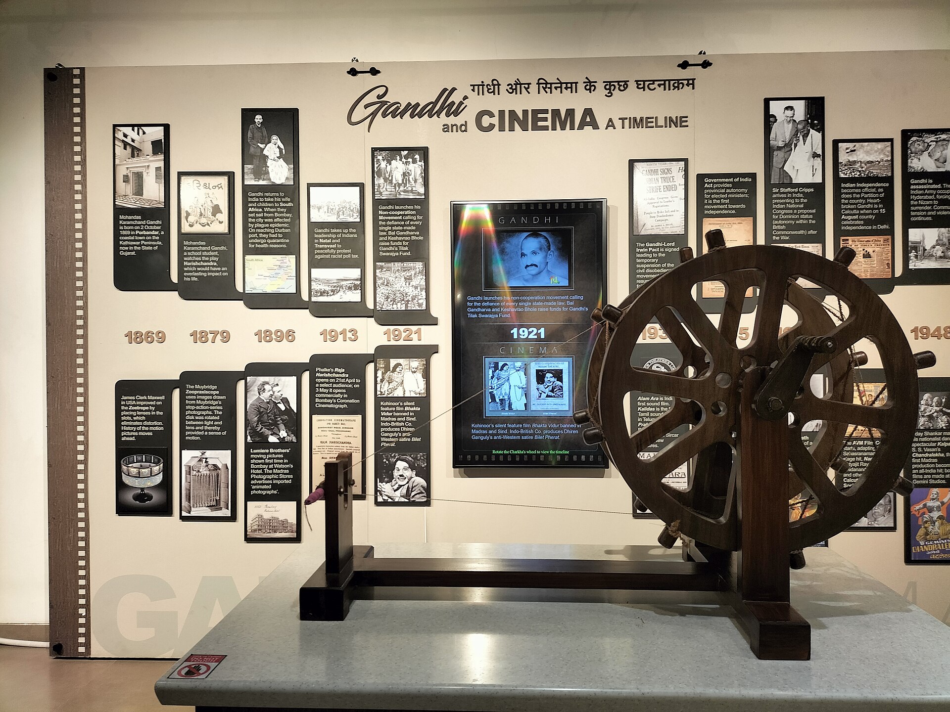 A museum exhibit details a timeline of Gandhi and cinema history, featuring vintage film reels.