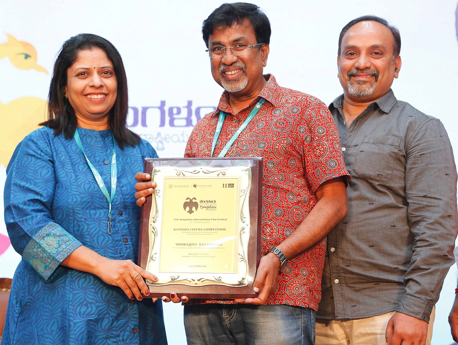 People pose with an award from the 11th Bengaluru International Film Festival, celebrating Kannada cinema.