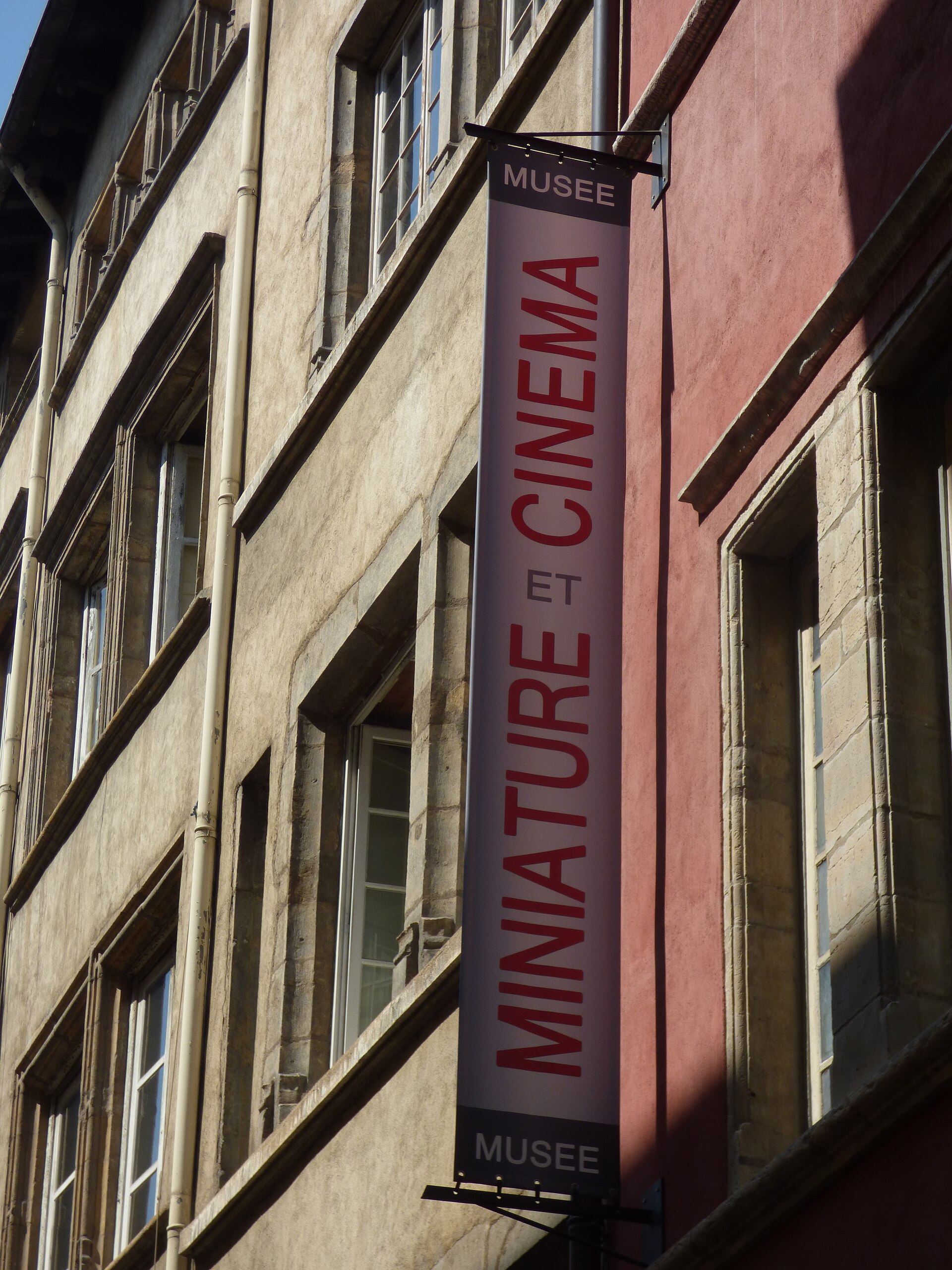 A building in Australia displays a banner for the Miniature and Cinema Museum, showcasing film history.